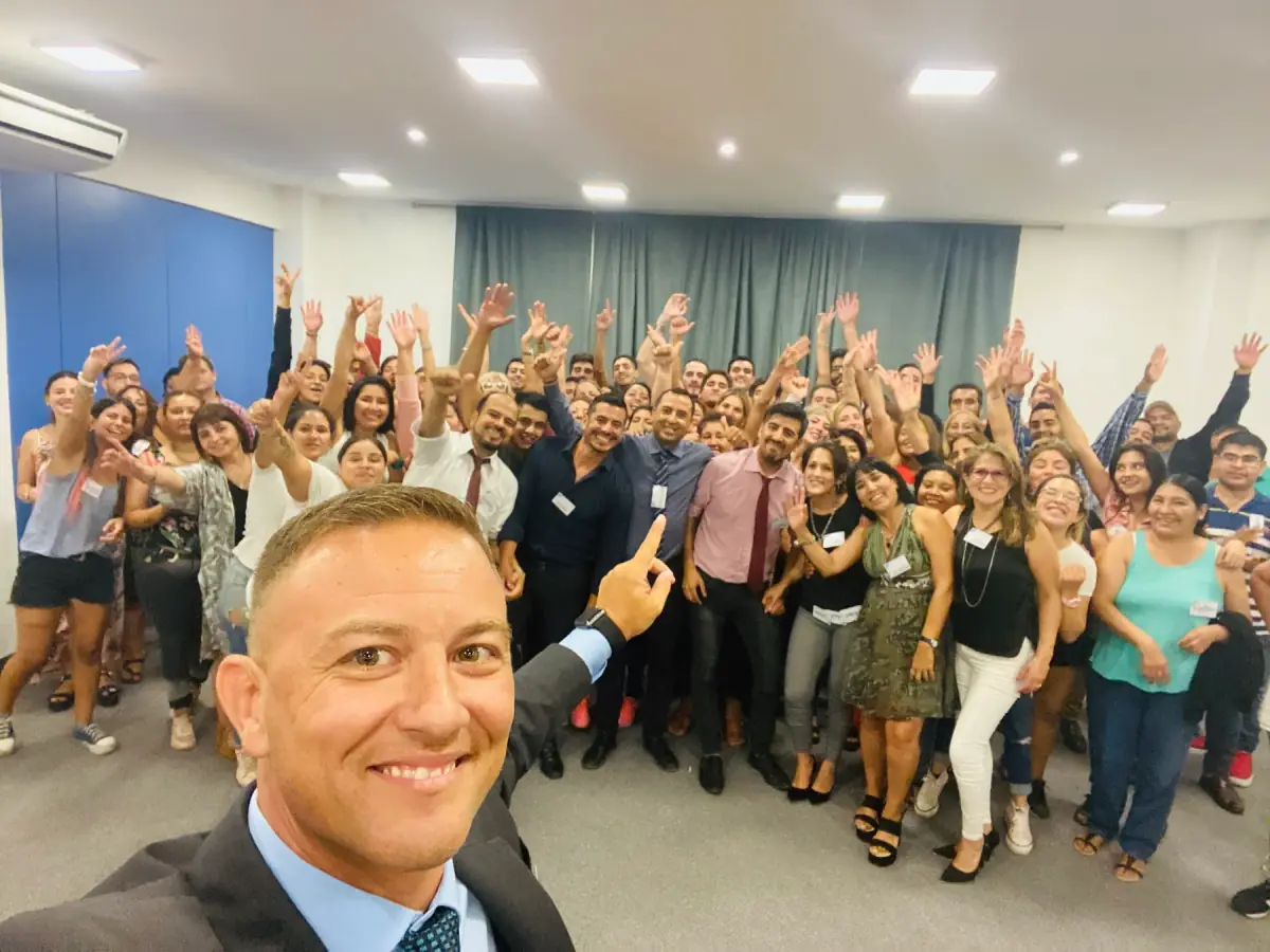 Ariel junto a un grupo de participantes con los brazos levantados