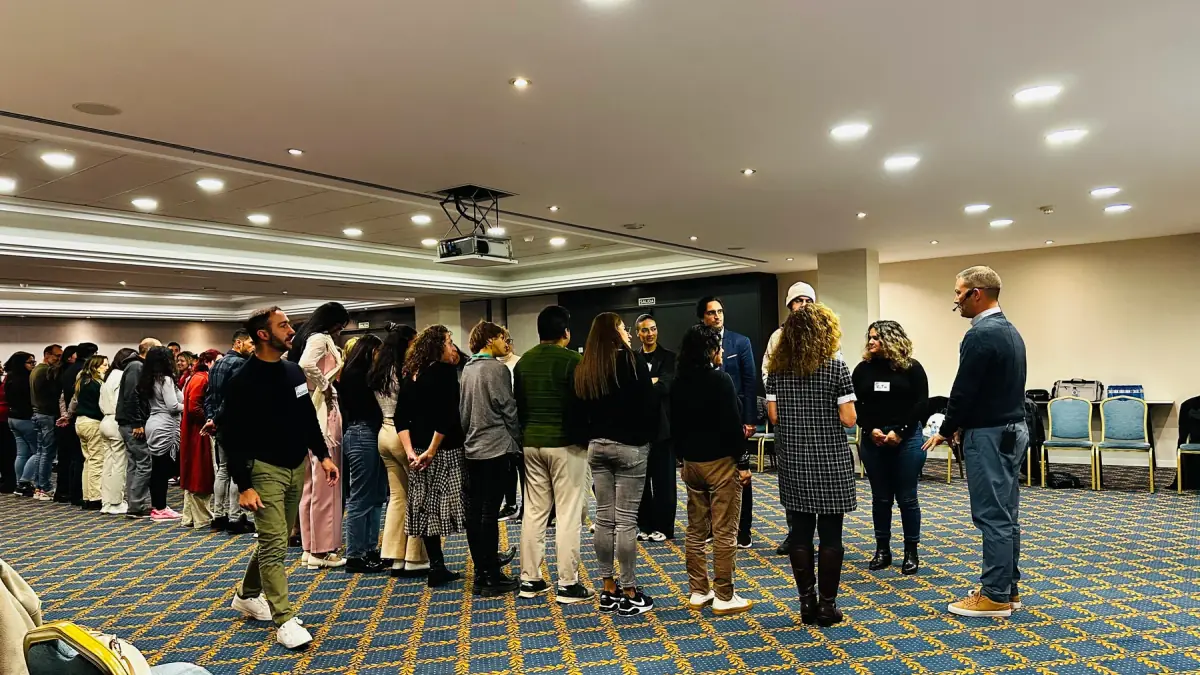 Grupo de participantes de pie en una dinámica de sala